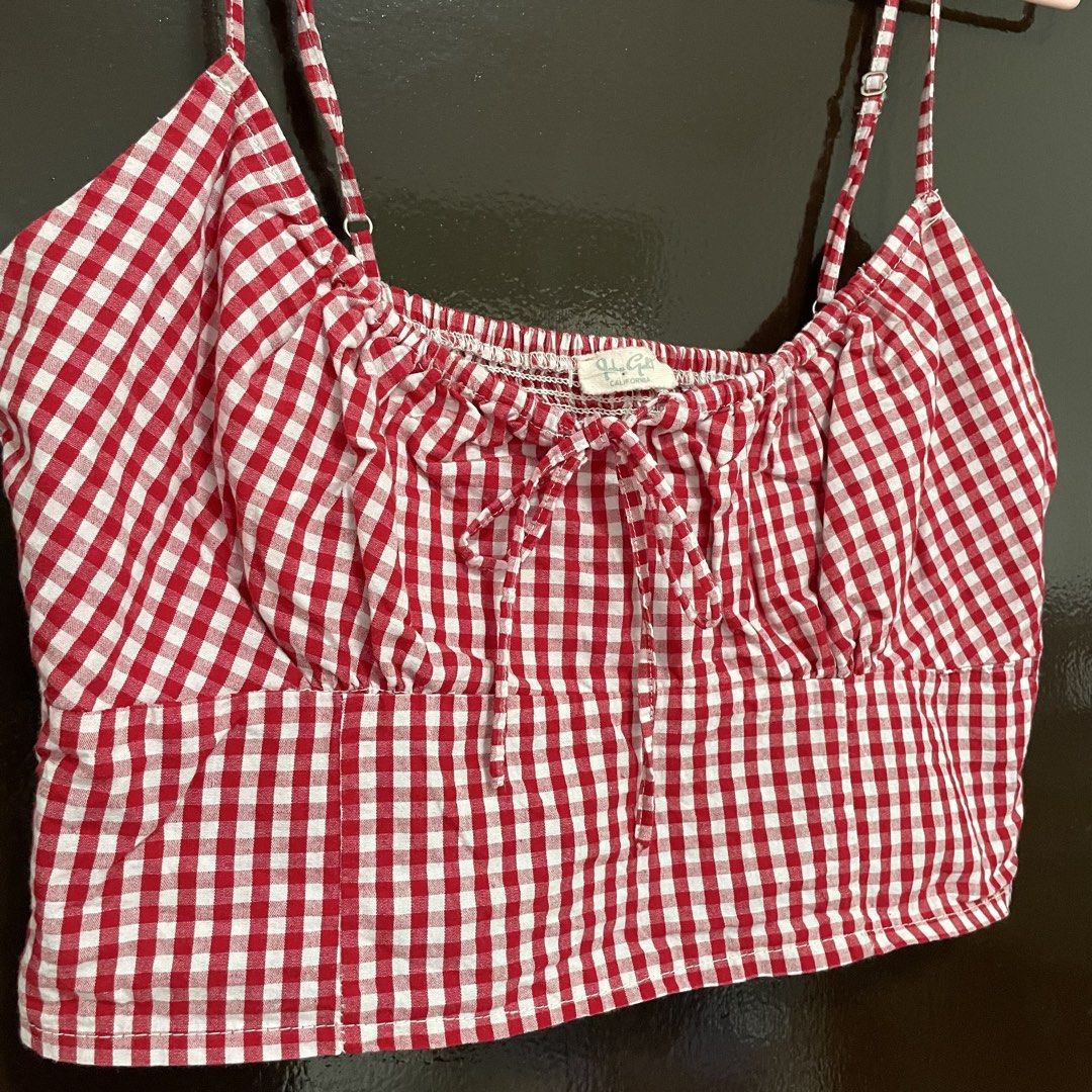 Brandy Melville Red Gingham Crop Top (Category: Sleeveless) located in Pasay City. Submitted by lovedbyzea (Listing ID 1467529869, Image 3). Description: - Brand: Brandy Melville - Style: Red and white gingham crop top with picnic vibe - Details: Sweetheart neckline with front tie bow - Fit: Adjustable spaghetti straps and stretchy smocked back panel.