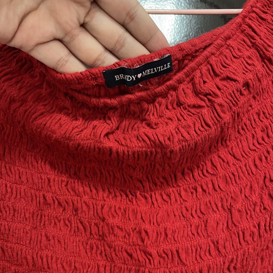 Brandy Melville Red Smocked Off-Shoulder Top (Category: Blouses) located in Pasay City. Submitted by lovedbyzea (Listing ID 1467530274, Image 3). Description: - Brand: Brandy Melville - Condition: Brand new with tag attached - Color: Vibrant cherry red - Fit: Super stretchy smocked texture, fits various body shapes nicely - Style: Short sleeves, off-shoulder neckline, crop top - Pairing: Easy to style with high-waisted jeans or skirts.