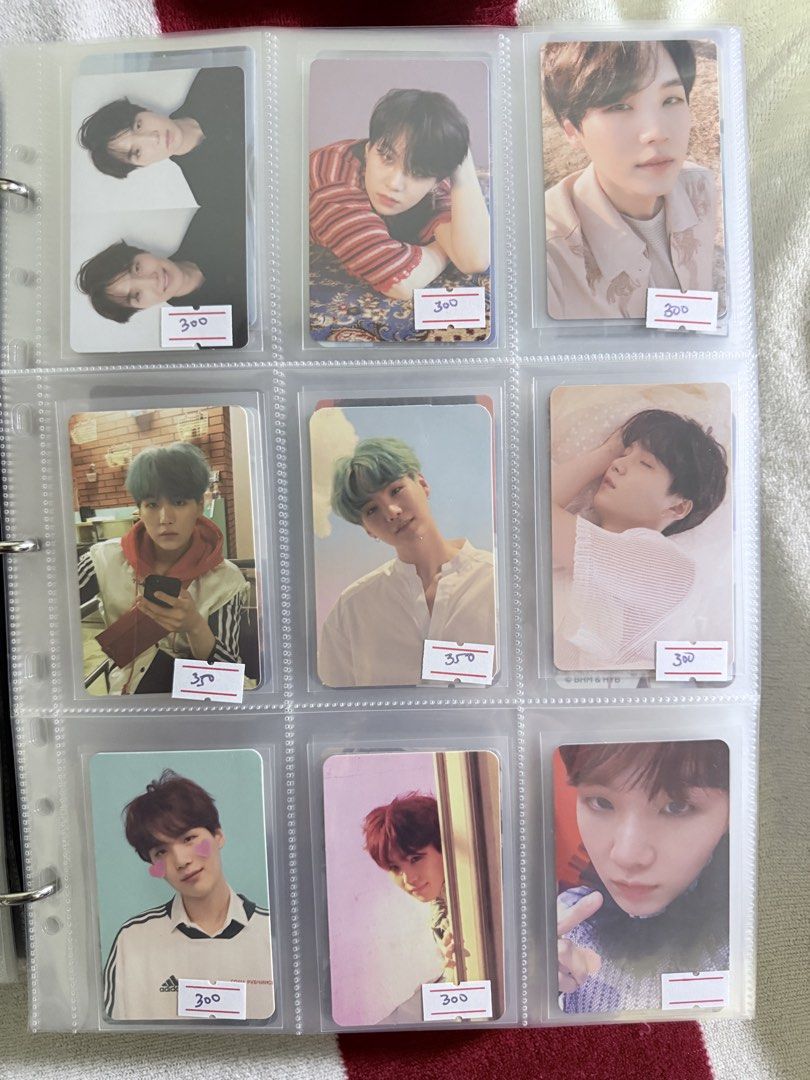 BTS Suga Min Yoongi Official Photocards (Category: K-Wave Merchandise) located in Manila. Submitted by kdd7141 (Listing ID 1467496757, Image 3). Description: Massive collection of BTS Suga photo cards organized securely in plastic binder sleeves. Includes various eras, hair colors like green, blue, black, and blonde, plus different outfits and poses. Individual price tags ranging from 150 to 350 attached on labels per slot. Great way to grab mult