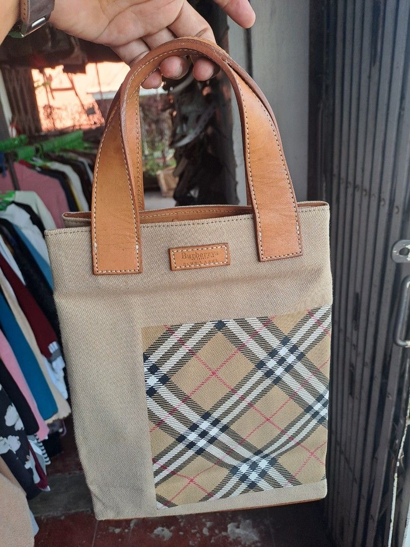 Burberrys Blue Label Canvas Tote Bag (Category: Tote Bags) located in Puerto Princesa. Submitted by jercksthriftph (Listing ID 1467372619, Image 1). Description: - Authentic Burberrys Blue Label tote bag - Crafted from durable beige canvas with leather handles and trim - Classic check pattern panel on the front with a leather brand patch - Double leather top handles for comfortable carrying - Clean interior structure with a sturdy base - Compact 