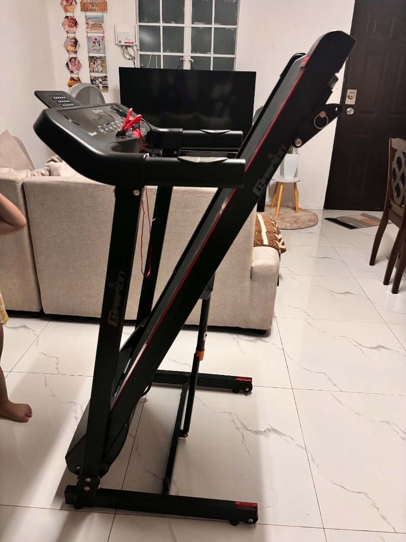Campion Focus 9227 Foldable Treadmill (Category: Cardio & Fitness Machines) located in Teresa. Submitted by kabuki101 (Listing ID 1467461478, Image 2). Description: - Model: Campion Focus 9227 treadmill - Space-saving design: Folds up vertically with wheels for easy rolling and storage - Display: Digital control panel for clear workout metrics - Safety: Includes red safety key with cord - Aesthetics: Black and dark grey frame with sporty red acce