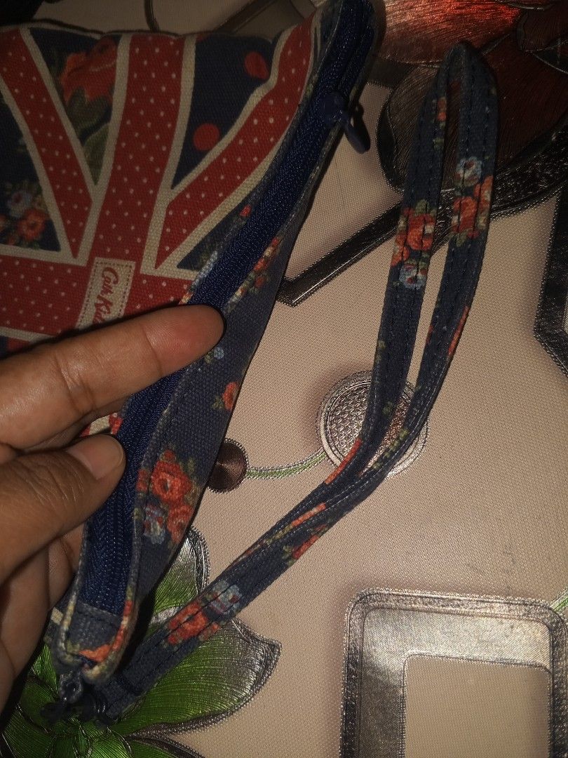 Cath Kidston British Union Jack Wristlet Pouch Bag (Category: Purses & Pouches) located in Magalang. Submitted by zeiansoria64090 (Listing ID 1467367134, Image 3). Description: - Brand: Cath Kidston - Design: Iconic Union Jack and London bus pattern on navy blue - Features: Secure zip top closure and attached fabric wrist strap - Interior: Clean dark blue fabric lining - Condition: Excellent / Well-maintained - Perfect for: Carrying small daily e