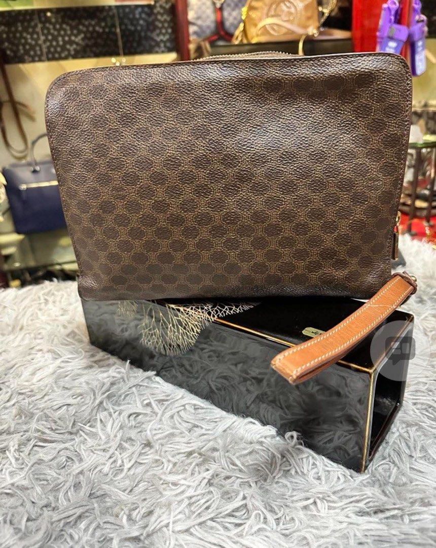 Celine Macadam Brown Monogram Clutch Bag (Category: Luxury Bags & Wallets) located in Dipolog. Submitted by adrian281994 (Listing ID 1467388188, Image 2). Description: - Brand: Celine - Material: Brown Macadam monogram coated canvas with tan leather trim - Closure: Zip top - Features: Removable wrist strap, dark fabric interior lining, and interior slip pocket - Origin: Made in Italy, stamped leather tag with serial code CE00/13 - Condition: Visi