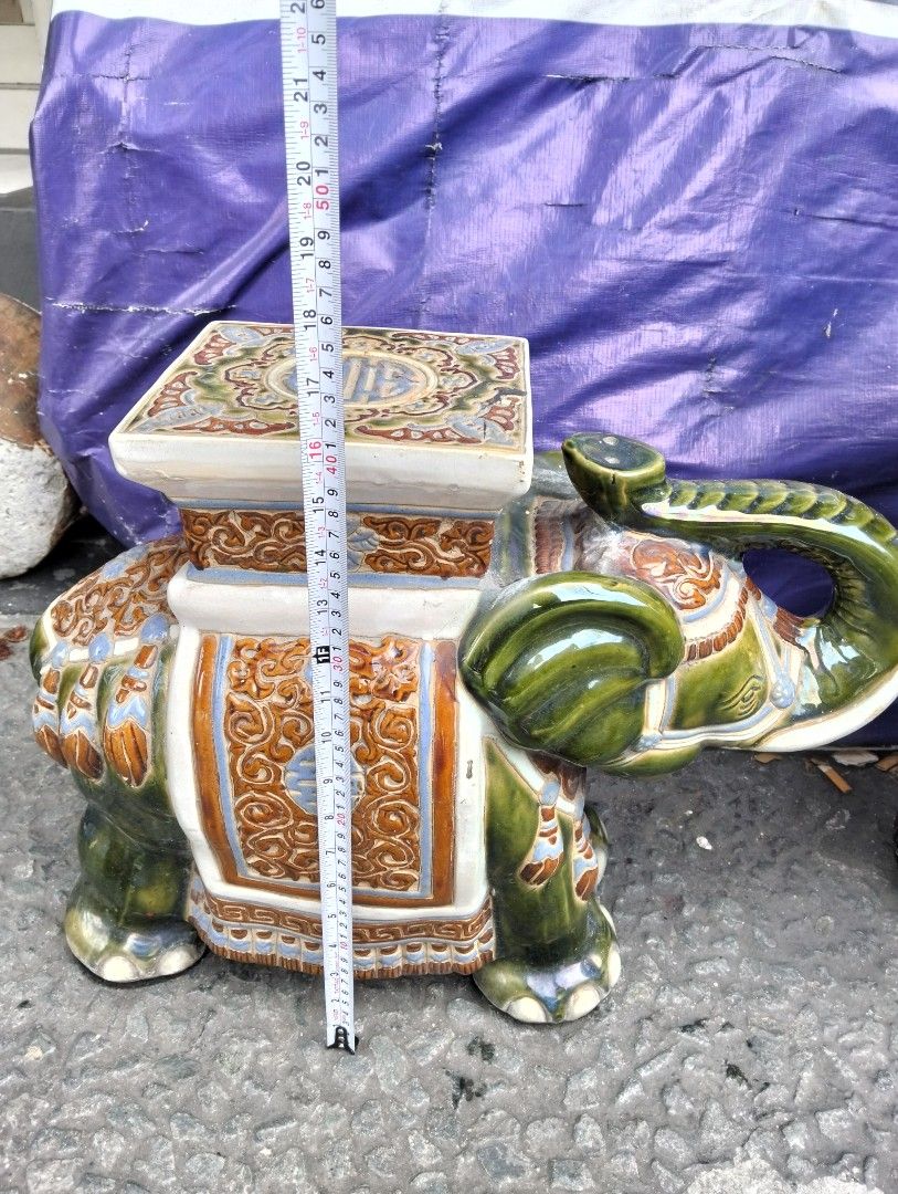Ceramic Elephant Garden Stool Plant Stand (Category: Pots & Planters) located in Manila. Submitted by raymundm36884 (Listing ID 1467403116, Image 2). Description: - Unique Design: Glazed ceramic elephant shape with a vibrant orange, blue, and white patterned saddle. - Traditional Details: Flat square top featuring classic Asian motifs and a longevity symbol. - Dimensions: Roughly 17 inches tall and 18 inches from trunk to back leg. - Versatile Us