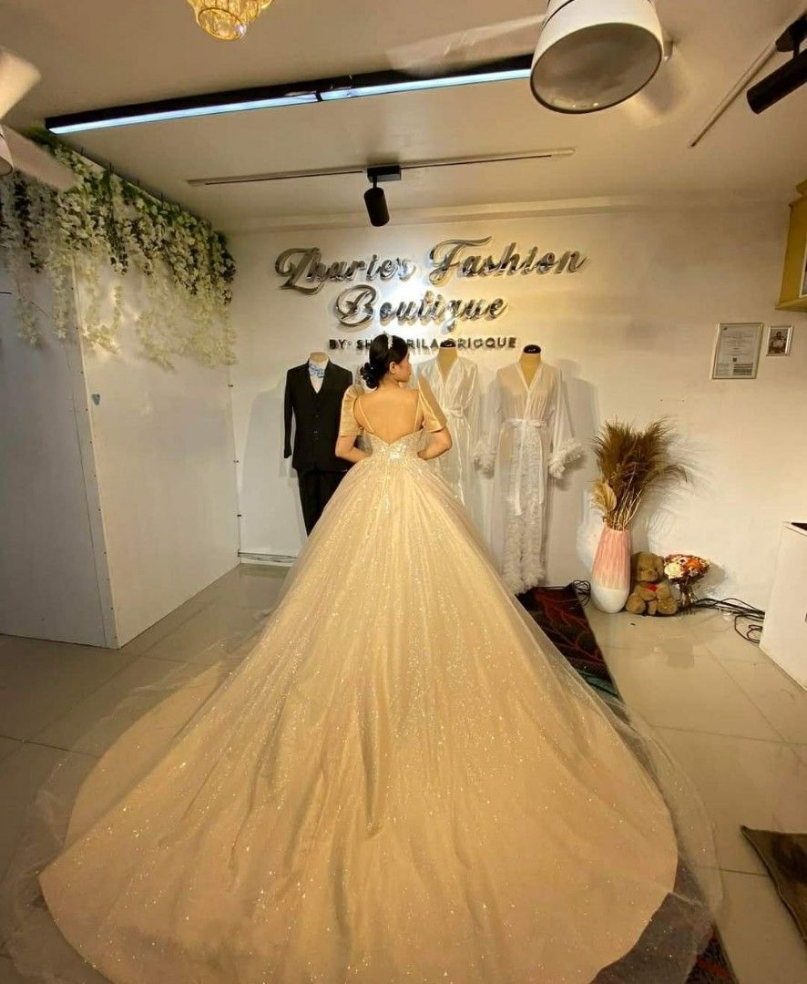 Champagne Wedding Gown (Category: Evening dresses & gowns) located in Manila. Submitted by euladelosr38638 (Listing ID 1467578873, Image 2). Description: Selling my UNUSED wedding gown from Zharie's Fashion Boutique Color: Champagne Size Medium to Large (adjustable cross-back) Glittered Tulle Long trail This was RTW pero pinaconvert ko to longsleeves/off shoulder style and cross back. The second photo is the actual photo and length (before alteri
