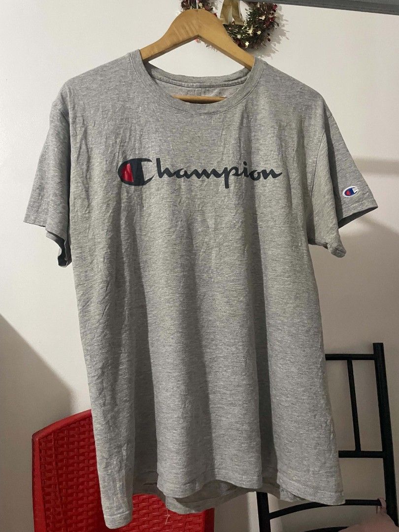 Champion Heather Grey Script Logo T-Shirt Medium (Category: Tshirts & Polo Shirts ) located in Manila. Submitted by mikeee03 (Listing ID 1467585765, Image 1). Description: - Brand: Champion - Color: Heather Grey - Size: Medium (tag on inner collar) - Design: Large script logo across chest with iconic embroidered C patch on left sleeve - Material: Soft, comfortable cotton blend - Origin: Made in El Salvador - Condition: Excellent, no stains or tea