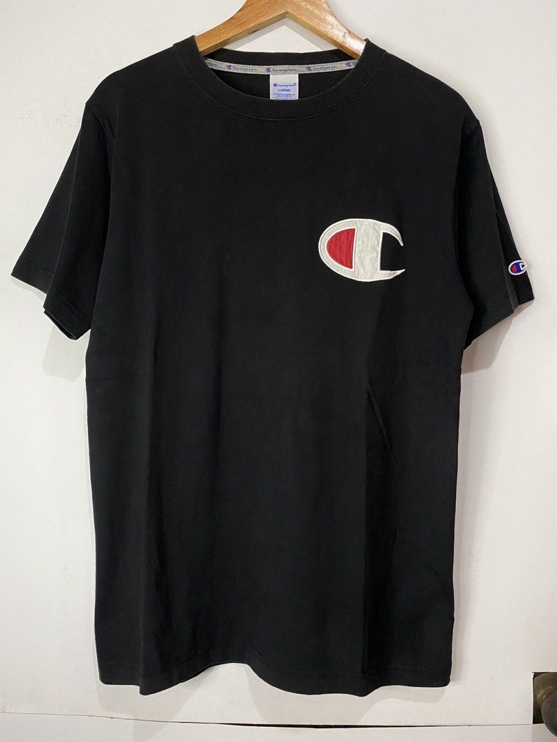 CHAMPION TSHIRT (Category: Tshirts & Polo Shirts ) located in Jaen. Submitted by oshimamark58418 (Listing ID 1467530767, Image 1). Description: - Brand: Champion - Color: Black - Size: Large - Design: Embroidered logo patch on chest and iconic C logo on left sleeve - Details: Printed neck taping and inner tag quote - Condition: Excellent, well-maintained.