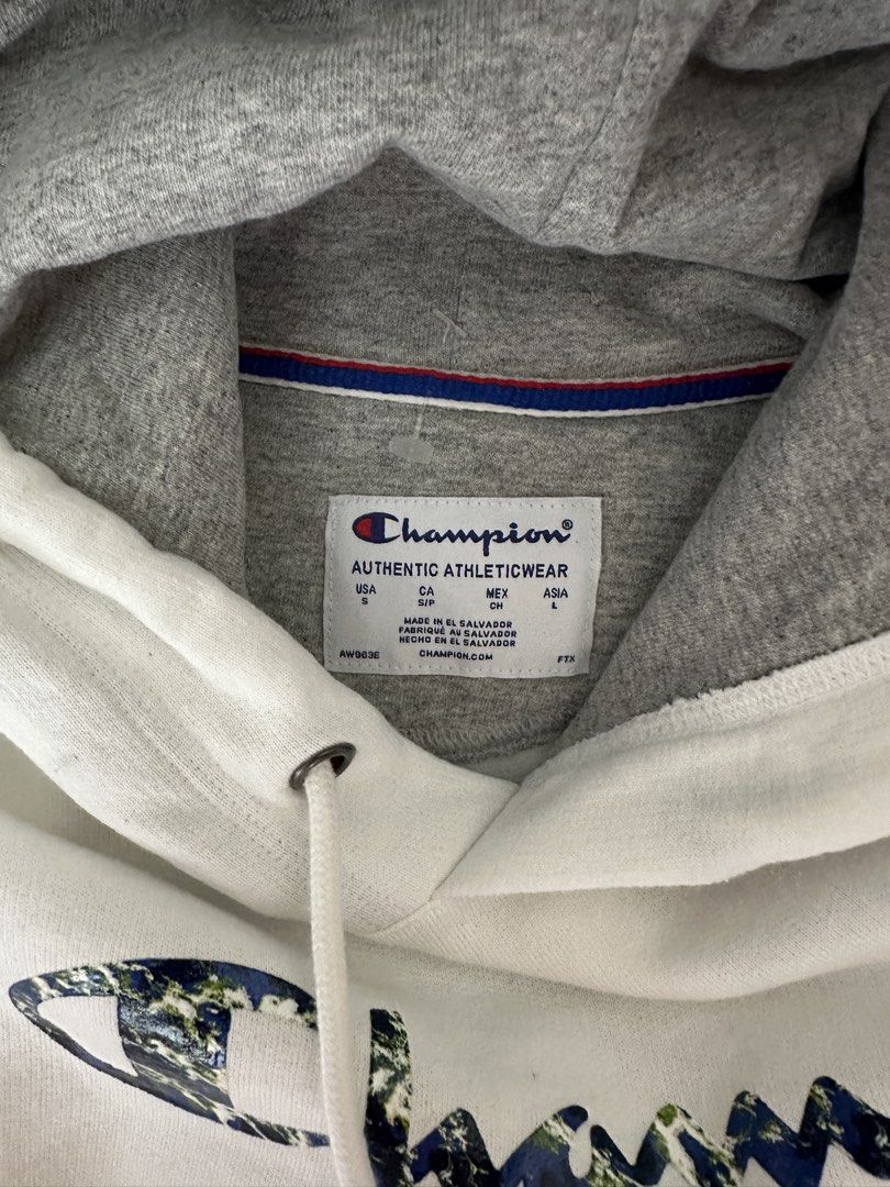 Champion White Hoodie with Earth Print Script Logo (Category: Hoodies) located in Mandaluyong City. Submitted by phvllis_ (Listing ID 1467450246, Image 2). Description: - Brand: Champion - Color: White with grey hood lining - Design: Script logo with blue and green earth print - Size: USA Small / Asia Large - Features: Kangaroo pocket, drawstring hood with metal aglets, embroidered C logo on left cuff - Origin: Made in El Salvador - Condition: Ex
