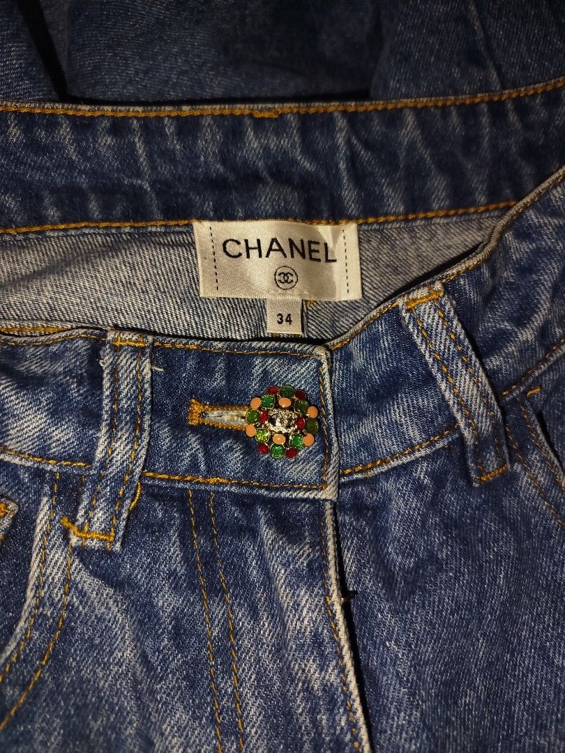 Chanel Denim Jeans Size 34 (Category: Jeans) located in Manila. Submitted by warrenwarr65028 (Listing ID 1467388417, Image 1). Description: - Brand: Chanel - Type: Blue denim jeans - Size: 34 (Made in Italy) - Fit: Structured fit with straight legs - Wash: Clean wash denim - Details: Decorative jeweled waist button, front patch pockets, and contrast yellow stitching - Condition: Excellent, with iconic brand and size labels inside the waistband.