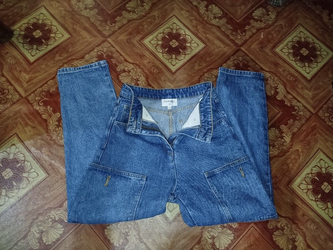 Chanel Denim Jeans Size 34 (Category: Jeans) located in Manila. Submitted by warrenwarr65028 (Listing ID 1467388417, Image 3). Description: - Brand: Chanel - Type: Blue denim jeans - Size: 34 (Made in Italy) - Fit: Structured fit with straight legs - Wash: Clean wash denim - Details: Decorative jeweled waist button, front patch pockets, and contrast yellow stitching - Condition: Excellent, with iconic brand and size labels inside the waistband.