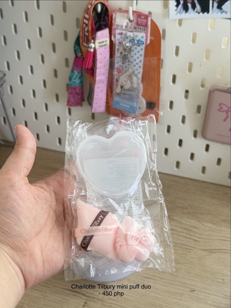 Charlotte Tilbury mini puff duo (Category: Makeup) located in Manila. Submitted by cinnmoroll (Listing ID 1467411338, Image 1). Description: - Mini makeup puff duo in an adorable clear heart-shaped storage case - Soft pink puffs featuring branded ribbon straps and a cute bow accent on one puff - Brand new, sealed in original plastic packaging - Perfect size for travel makeup bags and quick daily touch-ups - 100% authentic and ready to ship.