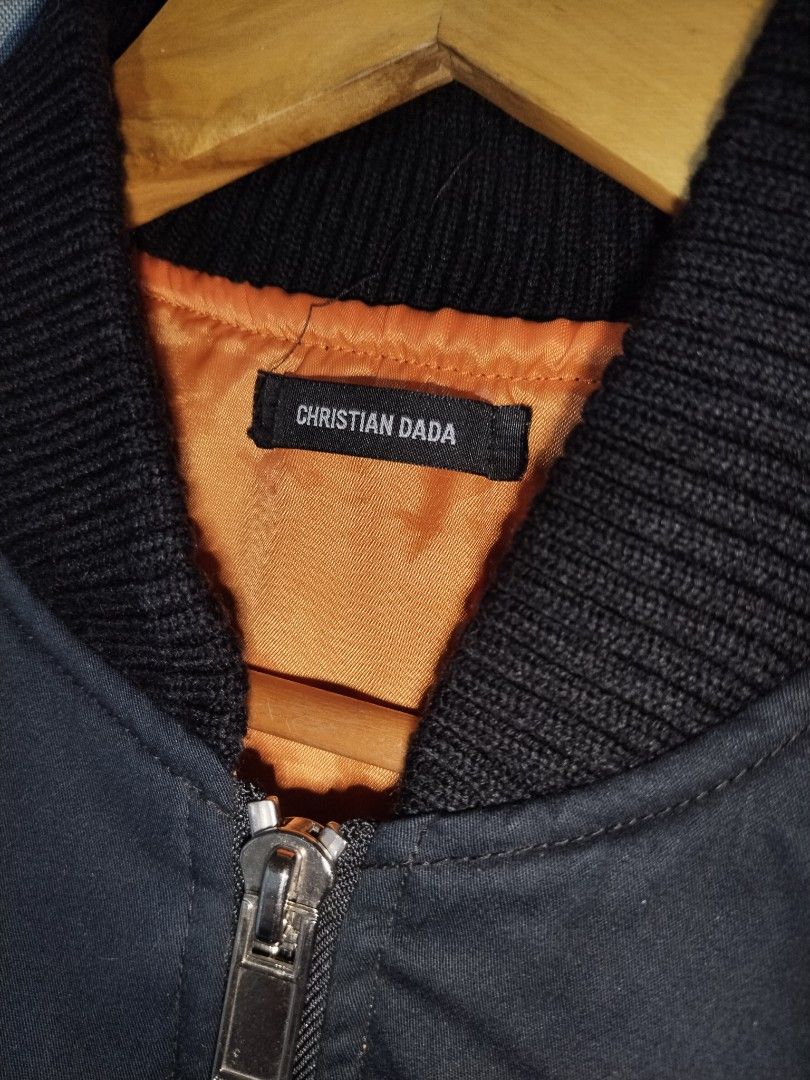 Christian Dada Black MA-1 Bomber Jacket (Category: Coats, Jackets and Outerwear) located in Pasig City. Submitted by loveforlux_2025 (Listing ID 1467411078, Image 3). Description: Christian Dada black bomber jacket. Orange lining inside, zipper closure, utility pocket on the left sleeve. Front pockets with snap buttons. Ribbed collar, cuffs, and hem. 100 percent cotton front, 100 percent polyester lining. Made in Japan. Model CD-16W-0107..