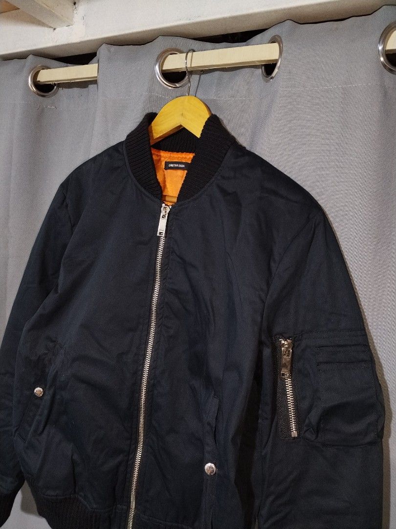 Christian Dada Black MA-1 Bomber Jacket (Category: Coats, Jackets and Outerwear) located in Pasig City. Submitted by loveforlux_2025 (Listing ID 1467411078, Image 2). Description: Christian Dada black bomber jacket. Orange lining inside, zipper closure, utility pocket on the left sleeve. Front pockets with snap buttons. Ribbed collar, cuffs, and hem. 100 percent cotton front, 100 percent polyester lining. Made in Japan. Model CD-16W-0107..
