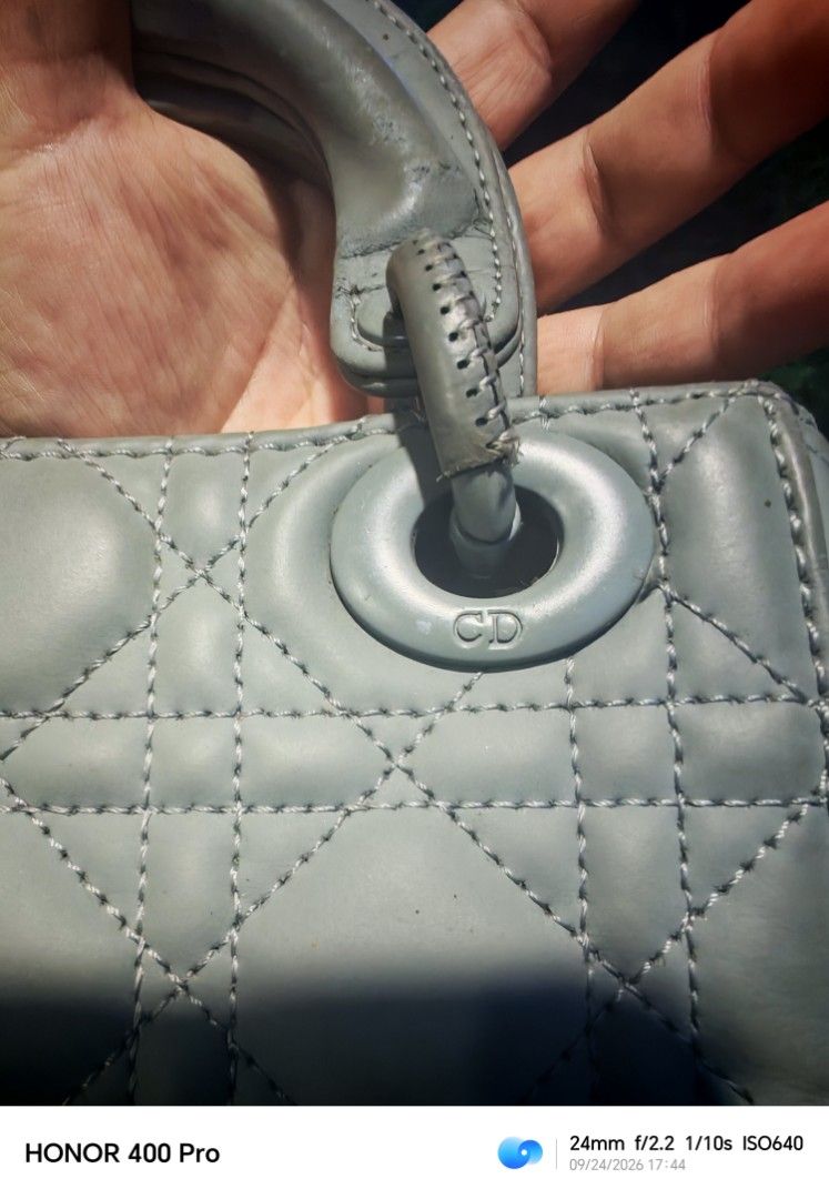 Christian Dior Lady Dior Mini Bag (Category: Luxury Bags & Wallets) located in Manila. Submitted by cleverwhale_45b7bc (Listing ID 1467375110, Image 3). Description: - Christian Dior mini handbag - Color: Light grey - Material: Quilted leather exterior - Interior: Red fabric with a zippered pocket - Embellishments: Iconic Dior charms - Condition: Shows some signs of wear on handles and corners, still beautiful..