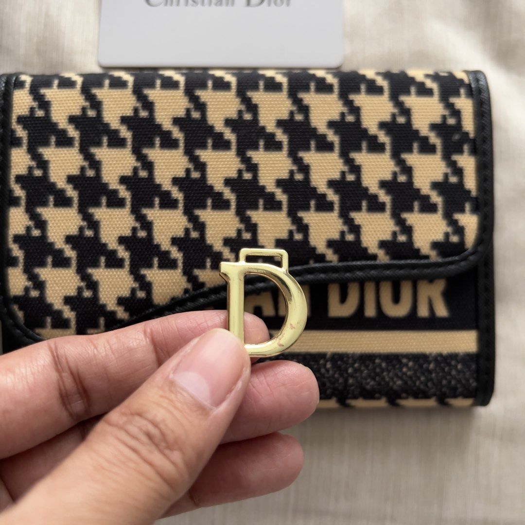 Christian Dior Saddle Wallet Houndstooth Black Beige (Category: Luxury Bags & Wallets) located in Pasig City. Submitted by jenscloset86 (Listing ID 1467389930, Image 2). Description: Christian Dior • Gifted to me, never used and it’s been in the box for long time. • The gold “D” is detached. • I cannot guarantee authenticity. • Please self-authenticate. Measurement (in inches): Length: 6” Height: 4.25”.