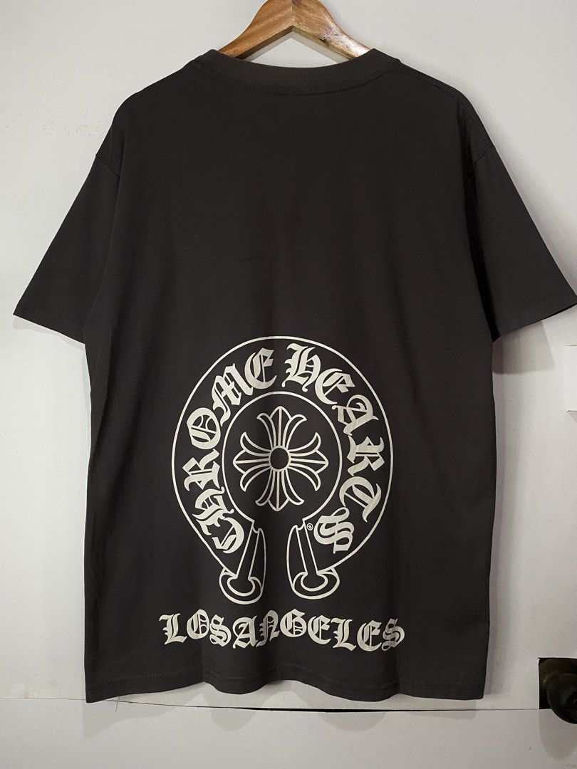 CHROME HEARTS TSHIRT (Category: Tshirts & Polo Shirts ) located in Jaen. Submitted by oshimamark58418 (Listing ID 1467531868, Image 1). Description: - Brand: Chrome Hearts - Color: Dark Gray - Size: XL (Flat measurements: 22" width x 29" length) - Condition: 7/10 pre-owned - Design details: Front chest pocket with horseshoe cross logo, large back graphic with 'Los Angeles' text, and CH logo near the hem - Style: Streetwear tee.