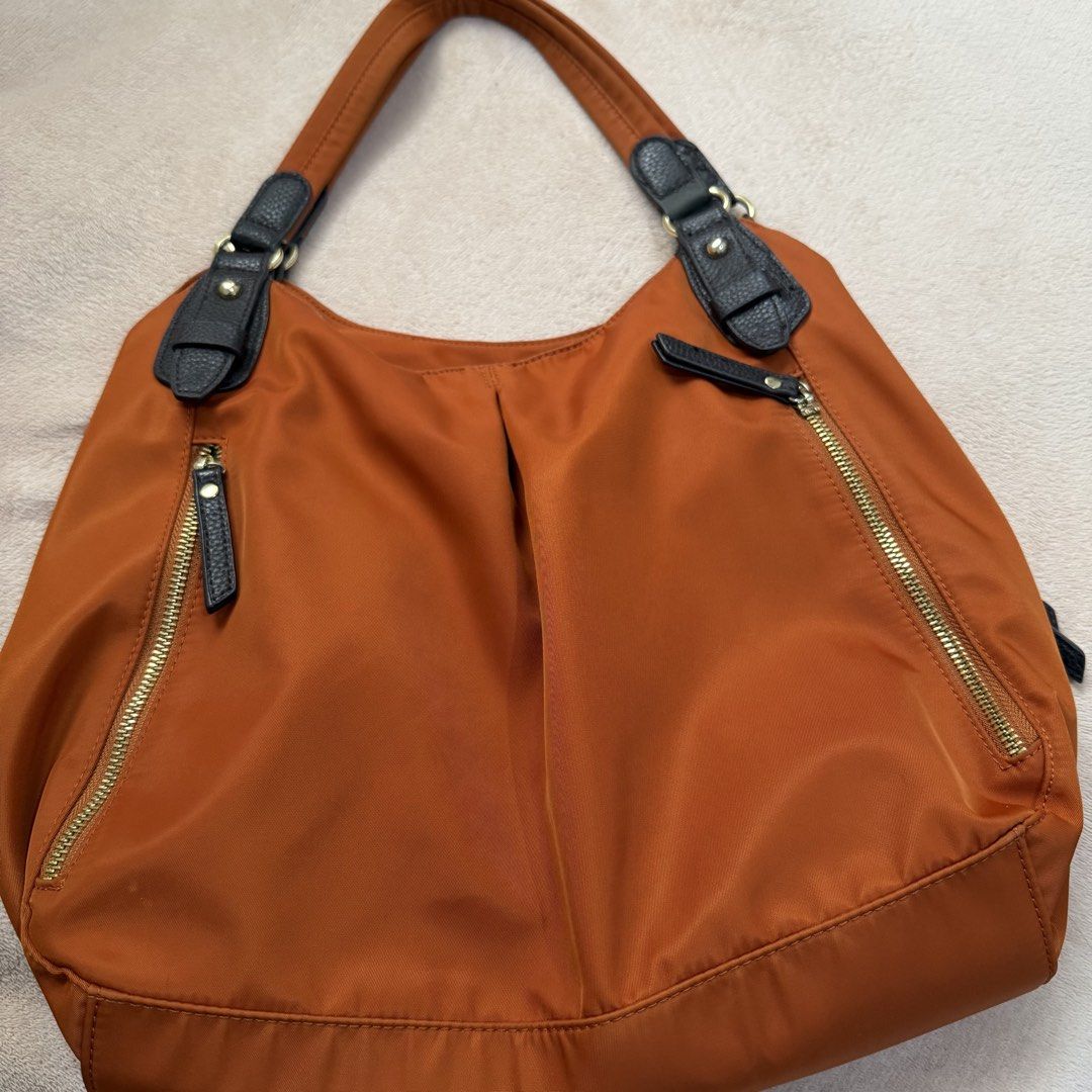 Closshi Orange Nylon Shoulder Bag (Category: Shoulder Bags) located in Zaragoza. Submitted by lerryparungao (Listing ID 1467375877, Image 1). Description: - Brand: Closshi - Color: Vibrant orange nylon with dark brown faux leather straps and trim - Pockets: Two vertical front zippered pockets and one inner zippered pocket - Interior: Lined with official Closshi brand tag - Features: Smooth zippers, sturdy shoulder straps, and a spacious design pe