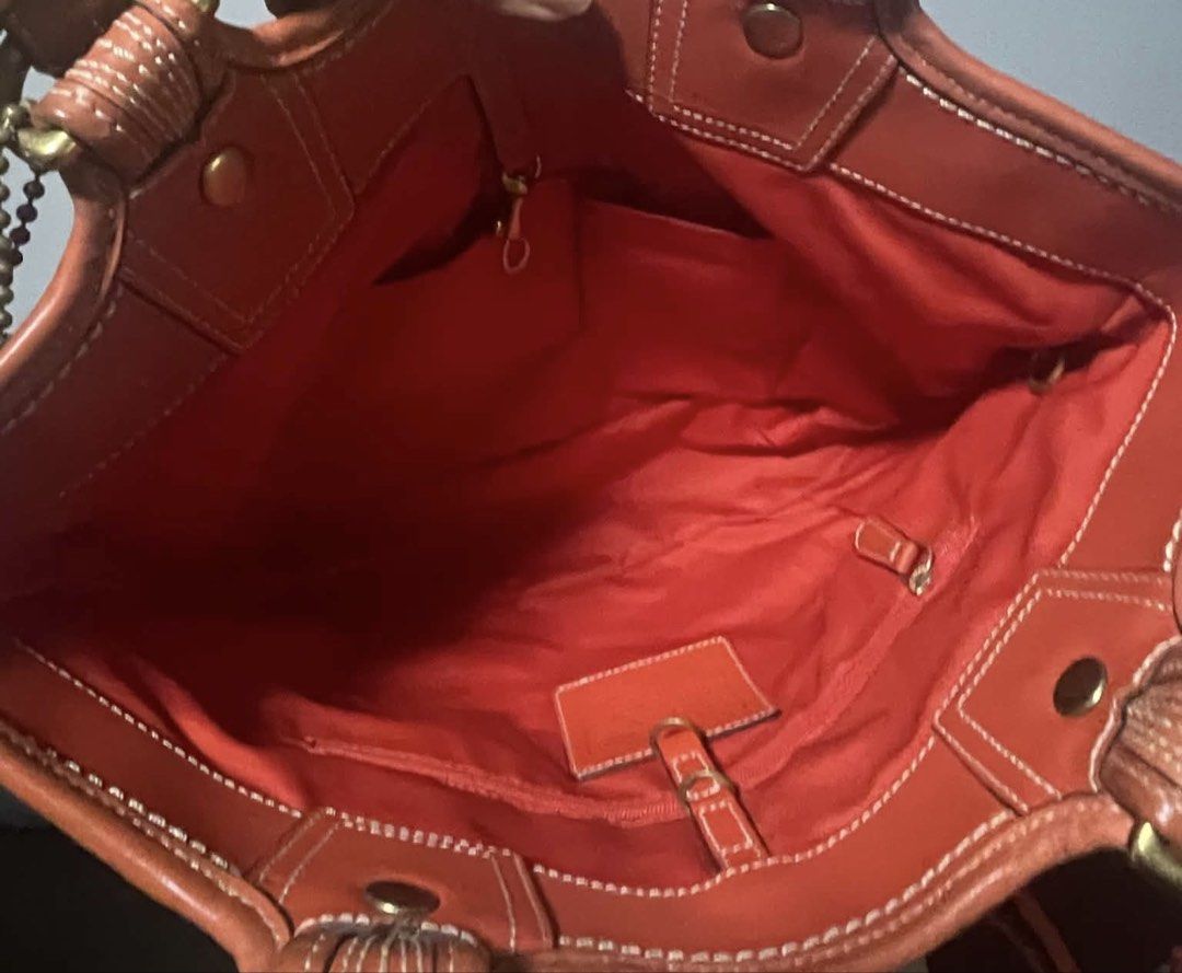 Coach Bleecker Straw / Leather Flower Tote Bag (Category: Shoulder Bags) located in Bacacay. Submitted by curatedsbyjj (Listing ID 1467523684, Image 3). Description: Coach Bleecker straw and leather tote bag featuring a decorative flower applique, sturdy leather handles, and a spacious red fabric interior with organizational pockets. Shows minor wear on the handles, but overall in good pre-loved condition. Perfect for casual wear and vacations. >