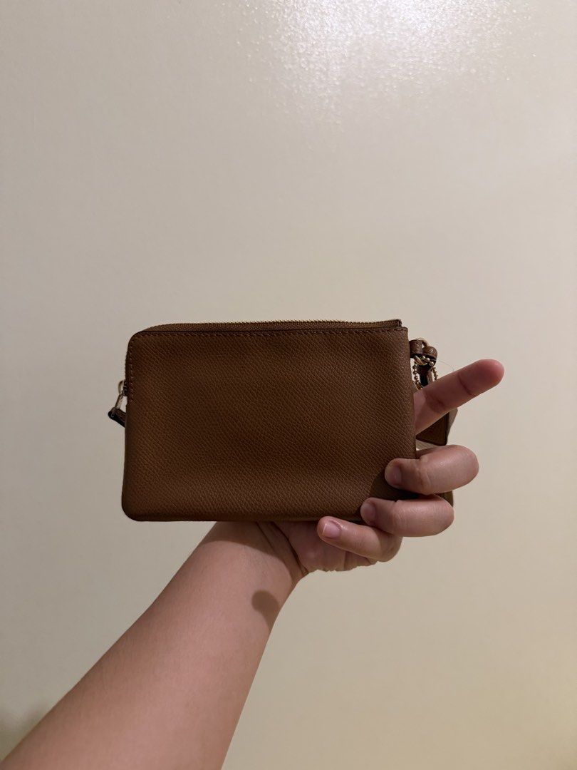 Coach Brown Leather Wristlet (Category: Luxury Bags & Wallets) located in Taguig. Submitted by wuuuby (Listing ID 1467503031, Image 3). Description: - Brand new Coach leather wristlet in rich brown - Features elegant gold hardware and secure top zip closure - Convenient attached wrist strap for easy carrying - Fabric-lined interior with built-in slip pockets - Includes original care instructions card and dust bag - Tag still attached.
