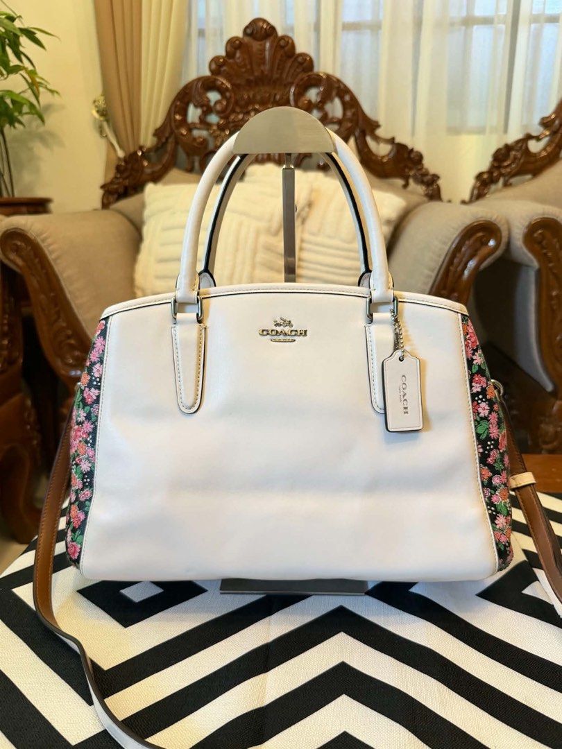 Authentic Coach Floral Side Panel Leather Satchel BodyBag (Category: Shoulder Bags) located in Santiago. Submitted by yrellagnoihsaf (Listing ID 1467430950, Image 1). Description: Coach Margot Carryall in Chalk White with Posey Cluster Floral Print . ✅ AUTHENTIC ✅ ALMOST NEW CONDITION NO FLAWS ✅ GENUINE LEATHER ✅ L 14” H 9” W 5” ✅ KILI OR BODY bag adjustable strap ❤️accessories not included Pm me for details ❣️❣️❣️.