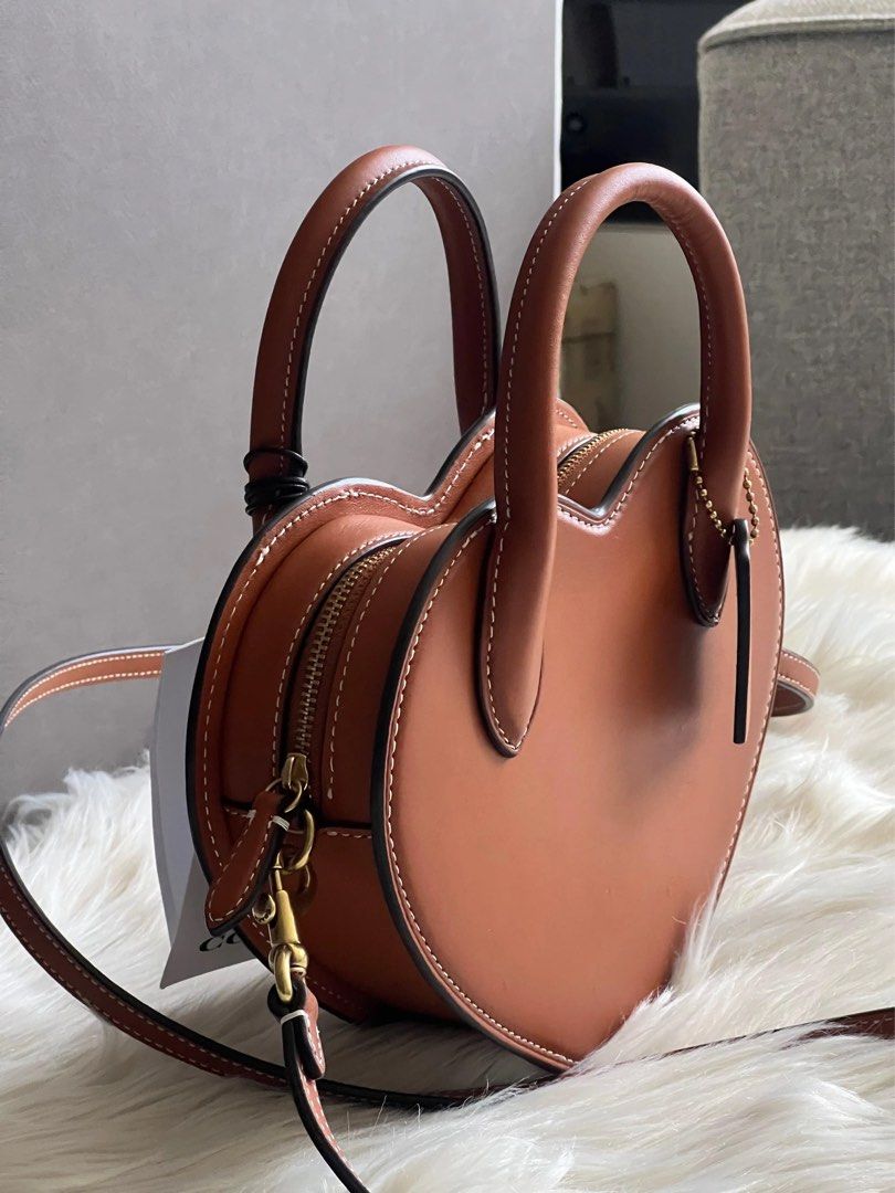 Coach Heart Crossbody Bag Brown (Category: Luxury Bags & Wallets) located in Quezon City. Submitted by pinkandpurpleshoppe (Listing ID 1467525095, Image 2). Description: - 100% Authentic Brown Coach Heart Crossbody Bag - Crafted from smooth leather with stylish contrast white stitching - Zip-top closure with structured top handles and a detachable shoulder strap - Elegant gold-tone hardware and matching hangtag - Comes complete with original dust