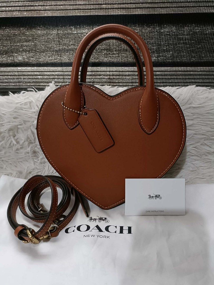 Coach Heart Crossbody Bag Brown (Category: Luxury Bags & Wallets) located in Quezon City. Submitted by pinkandpurpleshoppe (Listing ID 1467525095, Image 3). Description: - 100% Authentic Brown Coach Heart Crossbody Bag - Crafted from smooth leather with stylish contrast white stitching - Zip-top closure with structured top handles and a detachable shoulder strap - Elegant gold-tone hardware and matching hangtag - Comes complete with original dust