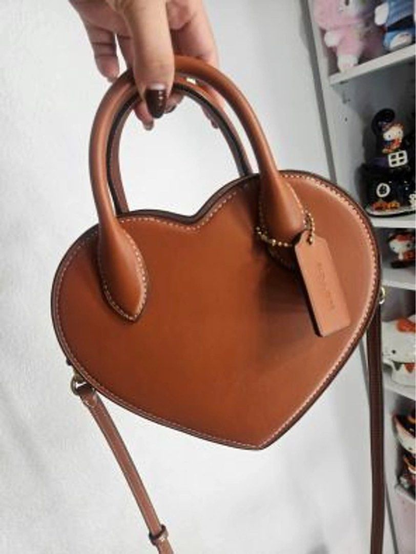 Coach Heart Crossbody Bag Brown (Category: Luxury Bags & Wallets) located in Quezon City. Submitted by pinkandpurpleshoppe (Listing ID 1467525095, Image 1). Description: - 100% Authentic Brown Coach Heart Crossbody Bag - Crafted from smooth leather with stylish contrast white stitching - Zip-top closure with structured top handles and a detachable shoulder strap - Elegant gold-tone hardware and matching hangtag - Comes complete with original dust