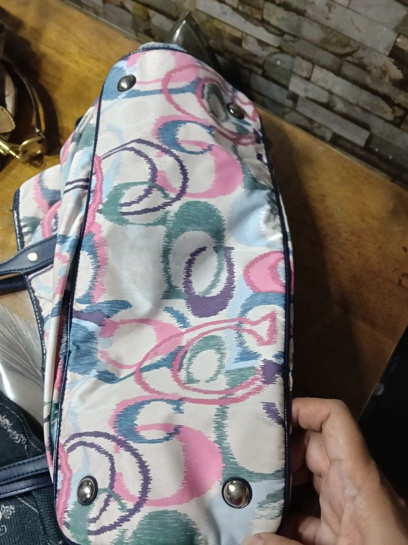 Coach Multi-color Print Tote Bag with Blue Straps (Category: Tote Bags) located in Quezon City. Submitted by bshoppe_ (Listing ID 1467486161, Image 3). Description: - Brand: Coach - Design: Colorful watercolor C-print pattern with dark blue leather handles and trim replace - Interior: Beige fabric lining with secure zipper pockets and slip compartments - Features: Drawstring details on the sides and metal protective feet on the bottom - Style: Ro