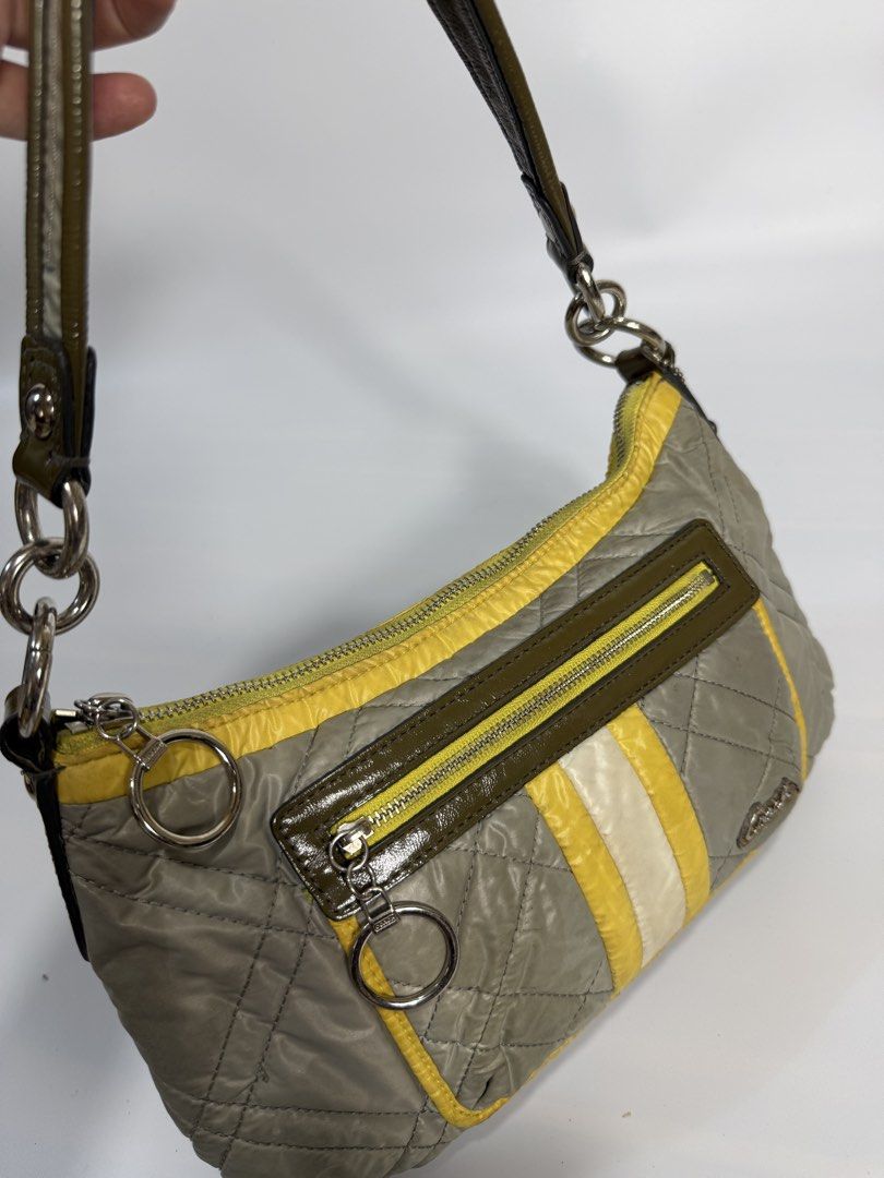 Coach Quilted Nylon Shoulder Bag Olive Green Yellow (Category: Luxury Bags & Wallets) located in Dasmarinas. Submitted by arjalaph (Listing ID 1467430121, Image 3). Description: - Authentic Coach shoulder bag in olive green and yellow quilted nylon - Front zip pocket with silver ring pulls and vertical stripe accent - Single dark green strap with edgy chain link attachments - Clean grey fabric lining with signature Coach branding - Includes origi