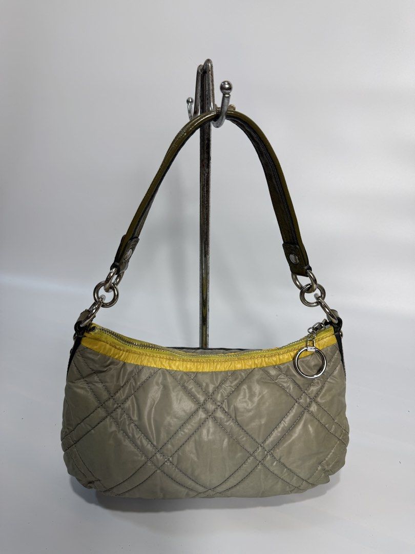 Coach Quilted Nylon Shoulder Bag Olive Green Yellow (Category: Luxury Bags & Wallets) located in Dasmarinas. Submitted by arjalaph (Listing ID 1467430121, Image 2). Description: - Authentic Coach shoulder bag in olive green and yellow quilted nylon - Front zip pocket with silver ring pulls and vertical stripe accent - Single dark green strap with edgy chain link attachments - Clean grey fabric lining with signature Coach branding - Includes origi