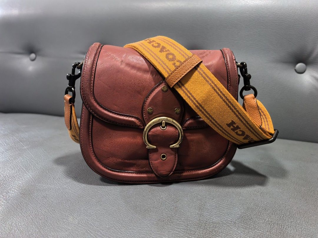 Coach Saddle Bag Brown Leather With Orange Strap (Category: Luxury Bags & Wallets) located in Cagayan de Oro. Submitted by pootx (Listing ID 1467511166, Image 1). Description: -please check the last photo sa issue pinalitan ko po ng strap/sling - Authentic Coach leather saddle bag in rich brown - Striking wide orange branded fabric shoulder strap with leather trim and dark hardware - Secure front buckle closure detail - Interior features dark lin