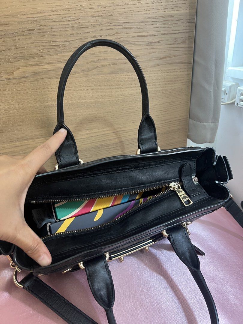 Coach Swagger (Category: Luxury Bags & Wallets) located in San Jose del Monte. Submitted by joy_ochoa (Listing ID 1467427509, Image 3). Description: Black pebble leather Coach bag with gold hardware. Turnlock closure on front, zipper top main compartment. Inside has a Coach storypatch and fabric lining. Dual top handles plus a removable, adjustable shoulder strap. Includes two Coach hangtags on the side. Fits daily essentials easily. .