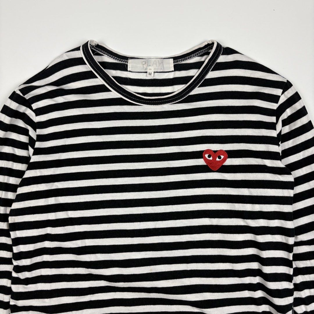Comme Des Garçons Play Heart-Patch Striped Long Sleeve (Category: Longsleeves) located in Quezon City. Submitted by 1106_collective (Listing ID 1467399897, Image 3). Description: Size: Medium Condition: 9/10 Material: 100% Cotton Made in: Japan Flaw / Defect: Minor dot yellow stain, minor loose stitch on the hem Dimension Width: 18” Length: 24” Shoulder: 16” Sleeve: 20”.