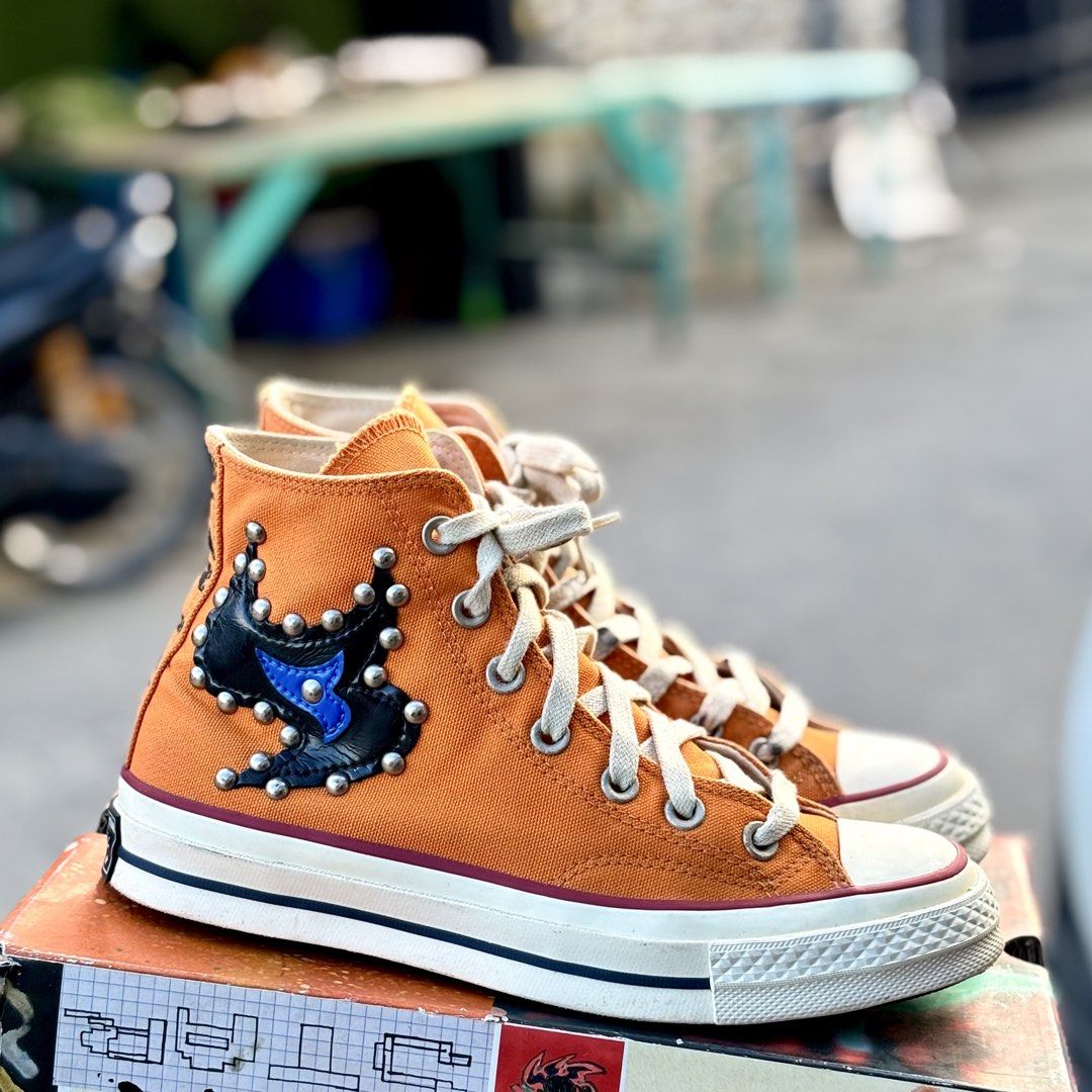 Converse Chuck Taylor x Come Tees High Top (Category: Sneakers) located in San Fernando. Submitted by kickslocker (Listing ID 1467378044, Image 2). Description: - Eye-catching orange canvas high tops with edgy black leather cutouts and metallic studs - Unique 'Come Tees' and 'Star Path' prints along the heels - Bold custom patterned black and white outsoles - Size: Men 5.5 / Women 7.5 (comfortably fits up to a Women 8.5) - Perfect for streetwear 