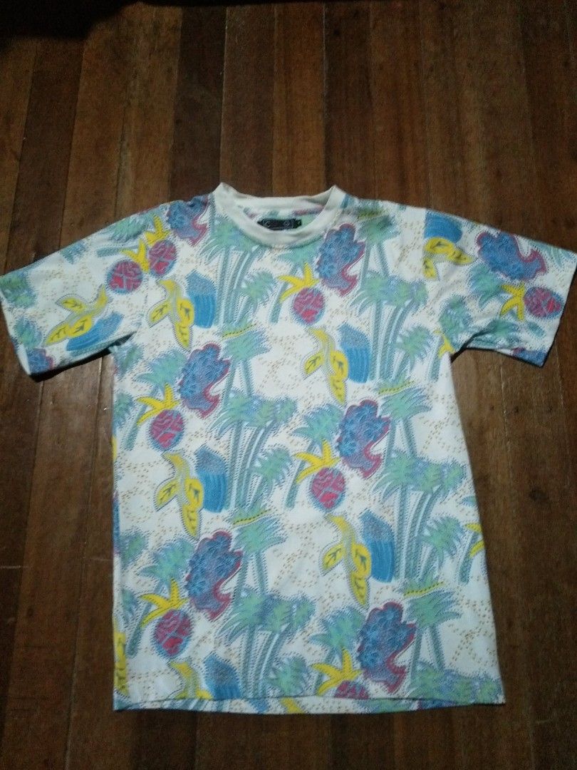 Coogi Tropical Print T-Shirt Medium (Category: Tshirts & Polo Shirts ) located in Camalaniugan. Submitted by mateojuliu73958 (Listing ID 1467402007, Image 1). Description: - Brand: Coogi - Size: Medium: 21.5/29 - Design: All-over tropical pattern (palm trees, pineapples, abstract shapes) - Colorway: Blue, pink, yellow, and green on a white base - Details: Crew neck, short sleeves - Material: 100% cotton - Origin: Made in China - Care Instructions
