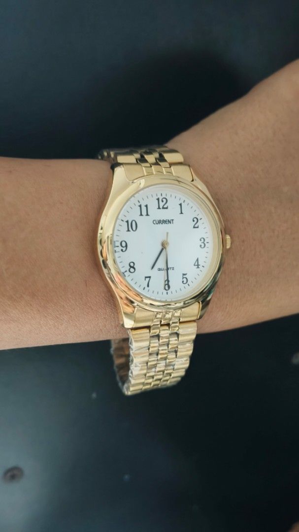 Current Gold Quartz Watch with White Dial (Category: Women's Watches) located in Taguig. Submitted by mercyeugen28914 (Listing ID 1467484295, Image 3). Description: - Brand: Current - Color: Shiny gold-tone - Dial: White round dial with bold, easy-to-read black numbers - Movement: Quartz movement with standard hands - Strap: Metal link bracelet with secure fold-over clasp - Condition: Brand new with protective plastic wrapping still intact on the