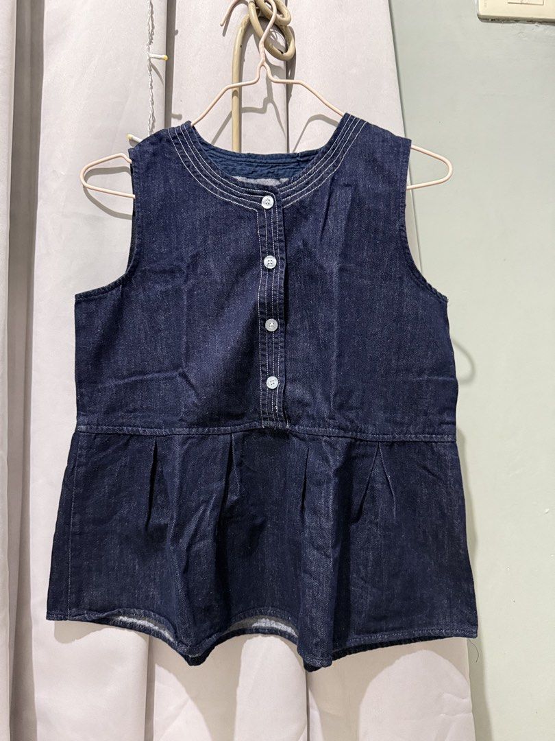 Dark denim sleeveless peplum top with front buttons (Category: Sleeveless) located in Cagayan de Oro. Submitted by ninaaam (Listing ID 1467477489, Image 2). Description: - Color: Dark blue denim - Style: Sleeveless top with a flared peplum hem and rounded neckline - Details: Four front white buttons and decorative stitching - Fabric: Soft, comfortable material - Fit: Hits around the hips; great for pairing with shorts or jeans.