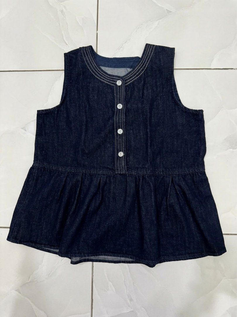 Dark denim sleeveless peplum top with front buttons (Category: Sleeveless) located in Cagayan de Oro. Submitted by ninaaam (Listing ID 1467477489, Image 1). Description: - Color: Dark blue denim - Style: Sleeveless top with a flared peplum hem and rounded neckline - Details: Four front white buttons and decorative stitching - Fabric: Soft, comfortable material - Fit: Hits around the hips; great for pairing with shorts or jeans.