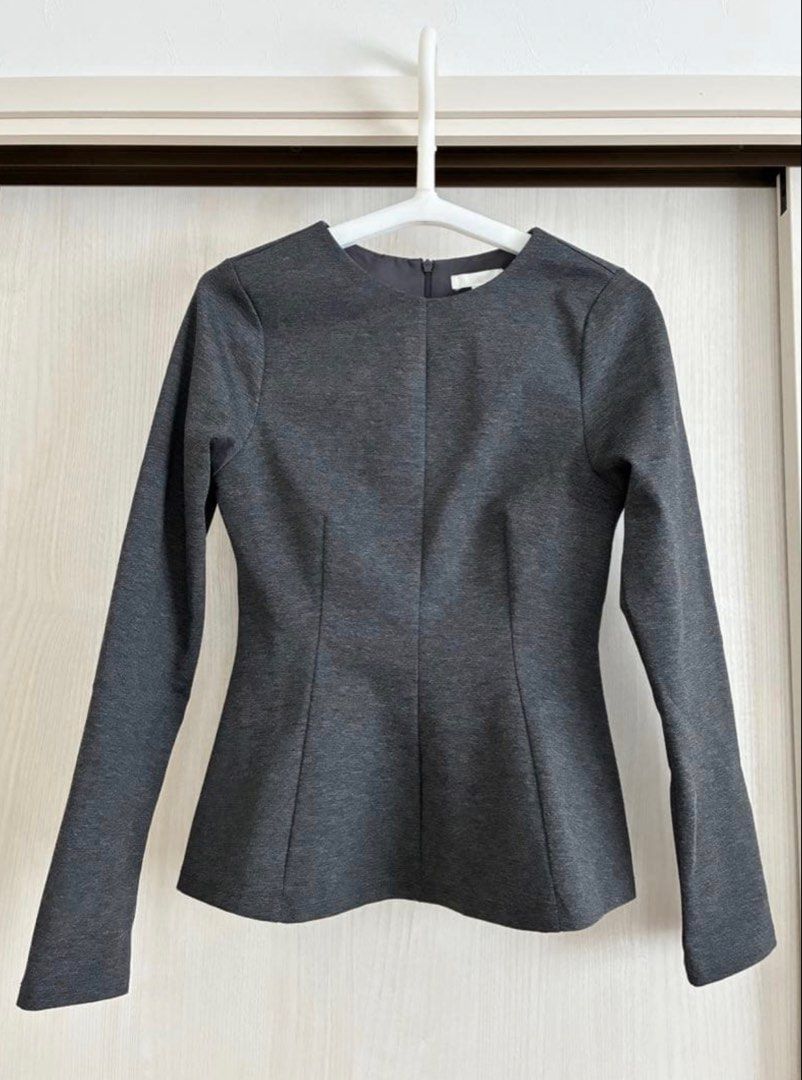 Dark Grey Peplum Long Sleeve Blouse (Category: Blouses) located in Manila. Submitted by katrinakatee (Listing ID 1467497254, Image 1). Description: - Color: Dark Grey - Style: Long sleeve with structured peplum waist and fitted silhouette - Neckline: Round neck - Closure: Back zipper - Material: Thick, shape-retaining jersey knit - Versatility: Perfect for both workwear and casual outings, easily paired with trousers or skirts.