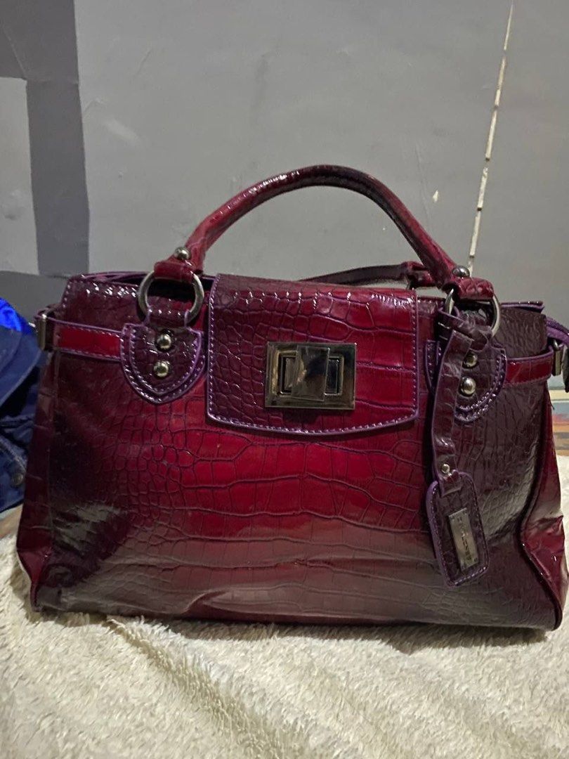 David Jones Burgundy Crocodile Embossed Handbag (Category: Luxury Bags & Wallets) located in Manila. Submitted by mabuyocarl (Listing ID 1467485729, Image 1). Description: - Color: Rich Burgundy with a glossy crocodile texture finish - Design: Structured shape with twin top handles and side strap details - Closure: Secure silver-tone twist lock on the front flap - Extras: Includes a matching branded luggage tag charm and durable metal hardware - 