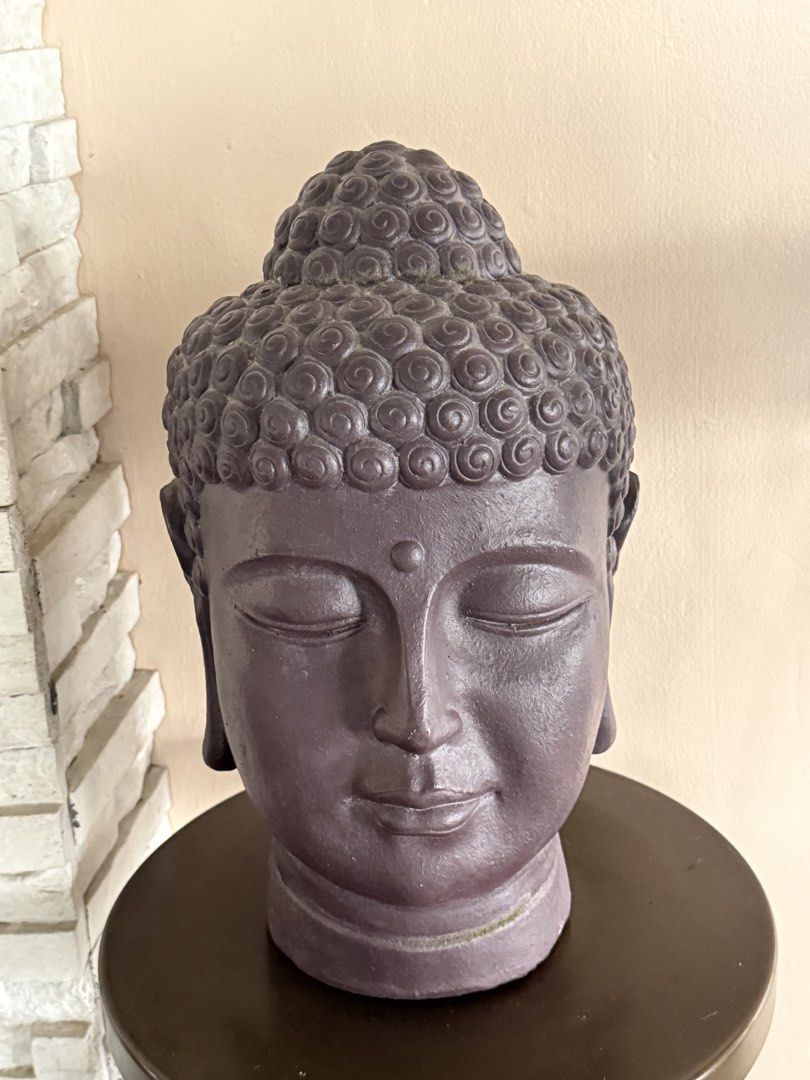Decorative Buddha head statue in dark purple finish (Category: Figurines & Statues) located in Manila. Submitted by chestercor71092 (Listing ID 1467434573, Image 1). Description: - Color: Dark purple - Design: Detailed curly hair texture and serene closed-eye expression - Base: Sits flat on a sturdy, dark circular pedestal - Material: Solid, heavy construction - Condition: Clean surface, ready to display - Ideal for: Home altar, shelf, or tableto