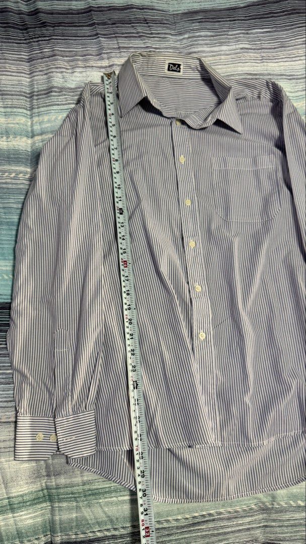 Dels Blue White Striped Long Sleeve Button-Up Shirt (Category: Formal Shirts) located in Quezon City. Submitted by kobeeeee_12 (Listing ID 1467530452, Image 2). Description: - Brand: Dels - Design: Blue and white stripes with classic collar and front button closure - Features: Single chest pocket, long sleeves with button cuffs, structured fit - Measurements: Length ~30 inches, Shoulder width ~18 inches - Versatility: Ideal for office wear or sma