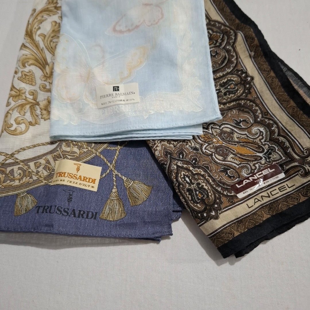 Designer Handkerchief Bundle Lancel Pierre Balmain Trussardi (Category: Handkerchief & Pocket Squares) located in Don Carlos. Submitted by PphiXi_Finds (Listing ID 1467440306, Image 1). Description: - Set of 3 authentic designer handkerchiefs - Brands and designs: Lancel (brown paisley), Pierre Balmain (light blue butterfly), and Trussardi (purple tassel) - Soft and high-quality fabric material - Comes with original brand tags still attached - Id