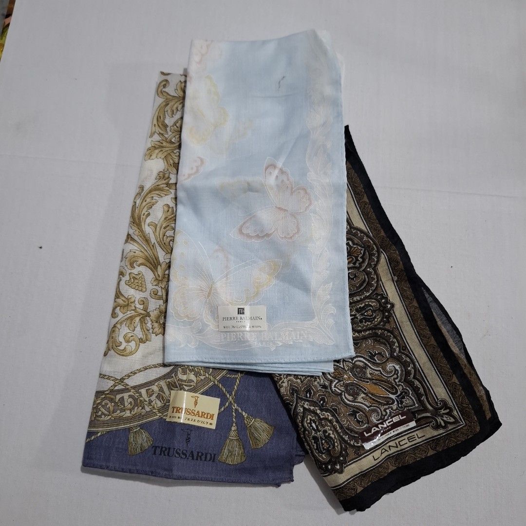 Designer Handkerchief Bundle Lancel Pierre Balmain Trussardi (Category: Handkerchief & Pocket Squares) located in Don Carlos. Submitted by PphiXi_Finds (Listing ID 1467440306, Image 2). Description: - Set of 3 authentic designer handkerchiefs - Brands and designs: Lancel (brown paisley), Pierre Balmain (light blue butterfly), and Trussardi (purple tassel) - Soft and high-quality fabric material - Comes with original brand tags still attached - Id