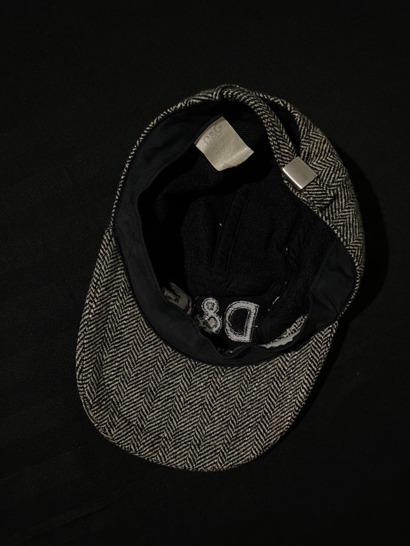 D&G Herringbone Wool Cadet Cap (Category: Caps & Hats) located in Manila. Submitted by jeproxthrift (Listing ID 1467572945, Image 2). Description: - Brand: Dolce & Gabbana (D&G) - Style: Cadet cap / Military hat - Pattern: Black and white herringbone tweed - Details: Embroidered D&G logo on the front, classic curved brim, and interior lining - Closure: Adjustable metal strap at the back for a custom fit - Condition: Excellent, timeless designer s