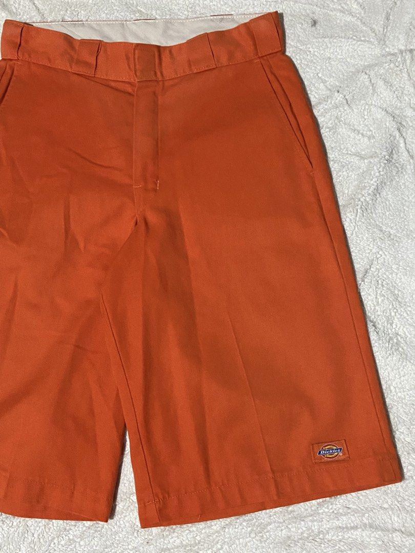 Dickies Orange Work Shorts (Category: Shorts) located in Polomolok. Submitted by tnecniv311 (Listing ID 1467536624, Image 3). Description: - Brand: Dickies - Color: Bright orange - Material: Sturdy twill fabric - Features: Utility pockets, woven logo patch, belt loops, zip fly, back welt pockets - Style: Great for skate or everyday workwear -Size 29 to 30 - Condition: Has a small hole near the bottom hem on one leg.
