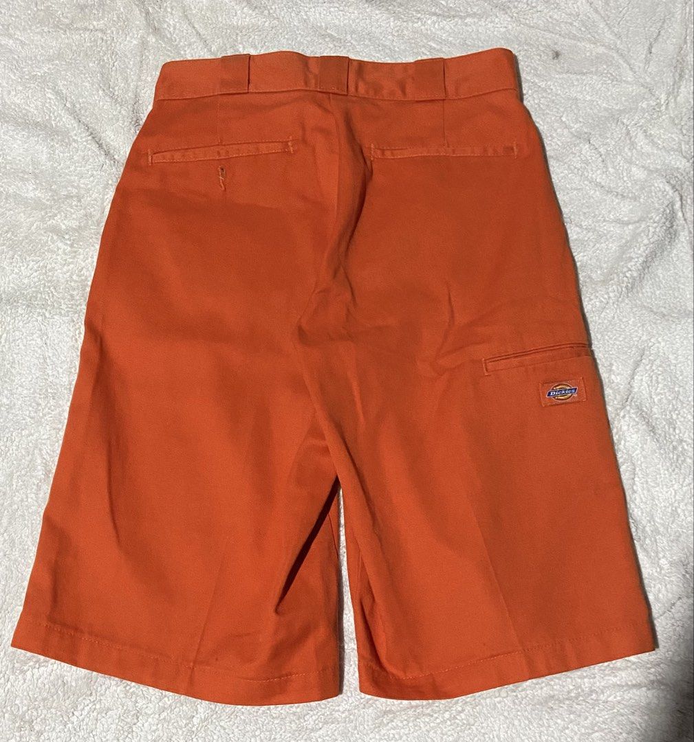 Dickies Orange Work Shorts (Category: Shorts) located in Polomolok. Submitted by tnecniv311 (Listing ID 1467536624, Image 1). Description: - Brand: Dickies - Color: Bright orange - Material: Sturdy twill fabric - Features: Utility pockets, woven logo patch, belt loops, zip fly, back welt pockets - Style: Great for skate or everyday workwear -Size 29 to 30 - Condition: Has a small hole near the bottom hem on one leg.