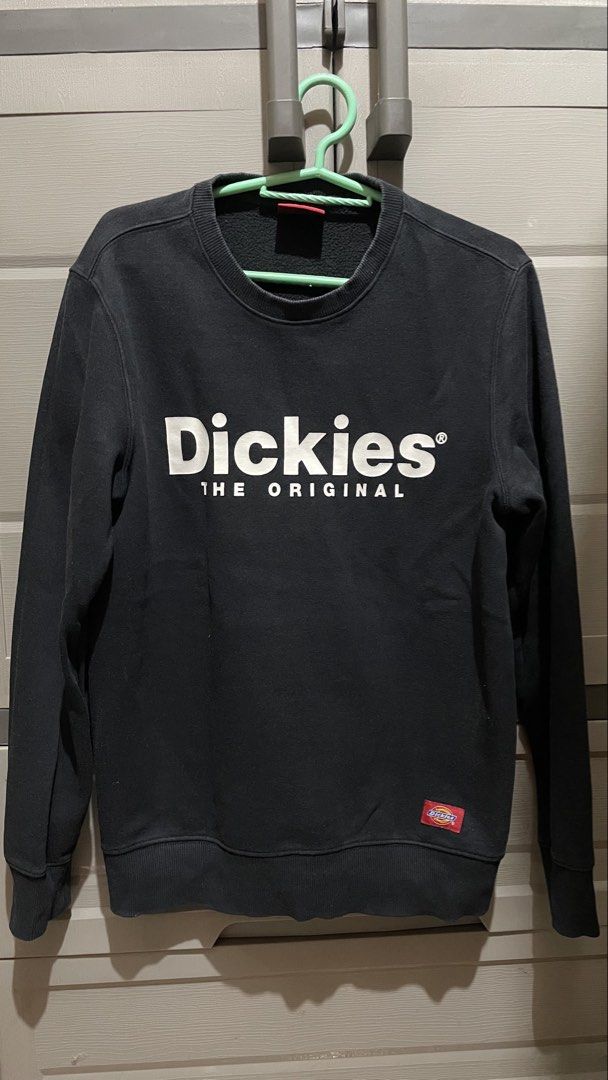 Dickies The Original Black Sweatshirt (Category: Coats, Jackets and Outerwear) located in Mandaluyong City. Submitted by il0v3thisg4m3 (Listing ID 1467400186, Image 1). Description: - Brand: Dickies - Color: Black with white chest lettering - Details: Small red Dickies logo patch near the hem, ribbed cuffs, collar, and hem - Lining: Thick fleece interior for extra warmth - Fit: Relaxed fit, long sleeves - Condition: Excellent casual piece for coo