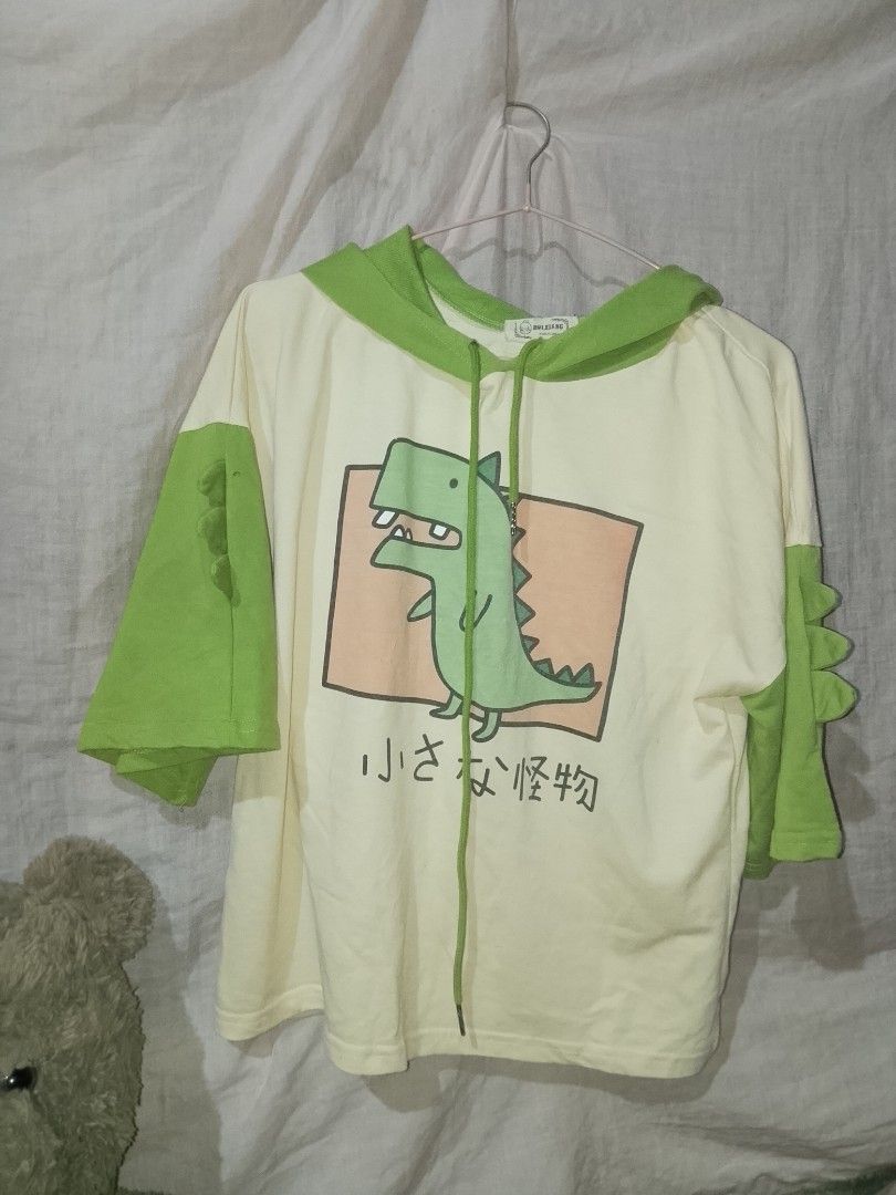 Dino hoodie with spikes (Category: Coats, Jackets and Outerwear) located in Adams. Submitted by yelri888 (Listing ID 1467499746, Image 1). Description: Little Monster Dino Hoodie with Spikes 💚🦖 Details: • Brand: Kawaii Boutique (Japanese text: Chiisana Kaibutsu = Little Monster) • Size: Free size fits M-XL (oversized) • Color: Cream & Green • Details: Hoodie with drawstring, 3D dino spikes on sleeves (both sides), dino print front • Fabric: Cot