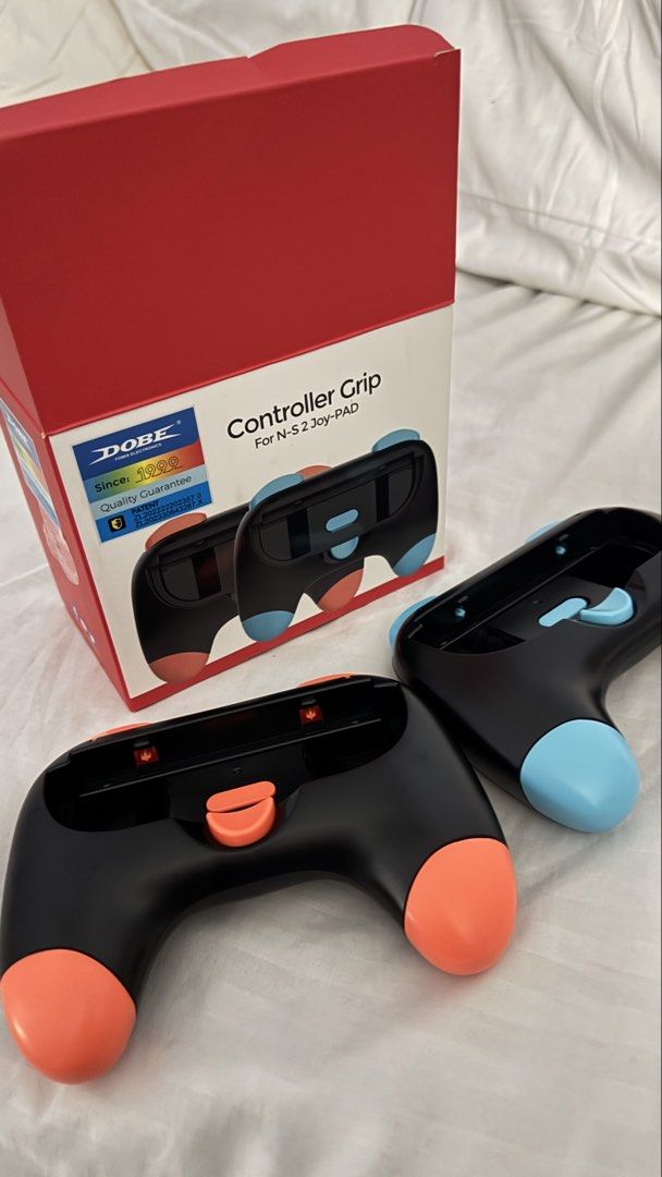 DOBE Controller Grip For N-S 2 Joy-PAD TNS-3163 Black (Category: Controllers) located in Manila. Submitted by miasgadgetz (Listing ID 1467531965, Image 1). Description: - Model: DOBE TNS-3163 Controller Grip Set - Compatibility: Designed for Nintendo Switch 2 Joy-Pads - Colorway: Sleek black with eye-catching neon orange and neon blue accent grips - Ergonomics: Comfortable hand-feel with large shoulder triggers for easier and better gaming - Pack
